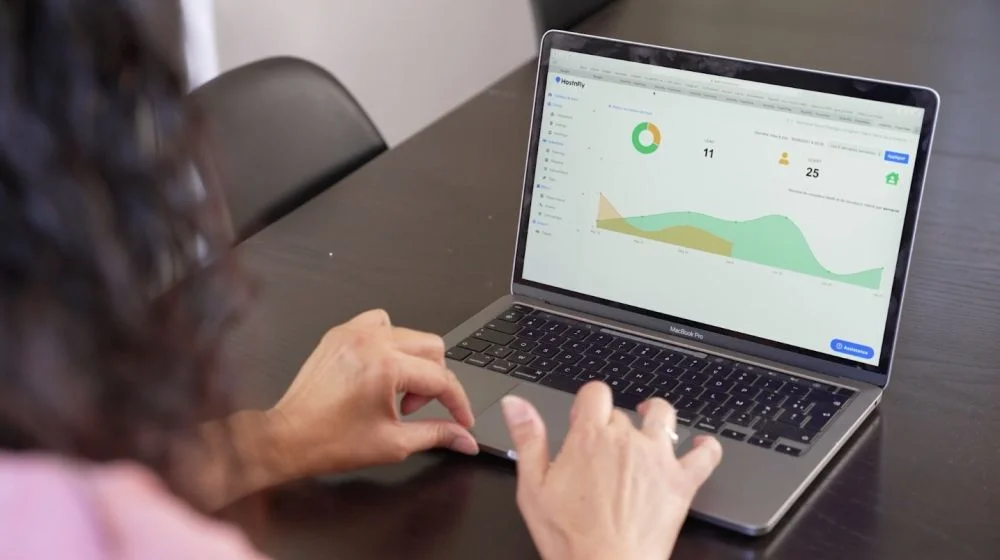 Une personne utilisant un ordinateur portable pour l’optimisation des revenus des annonces Airbnb